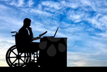 Silhouette of a man a businessman disabled in a wheelchair sitting at a table. The concept of working disabled people
