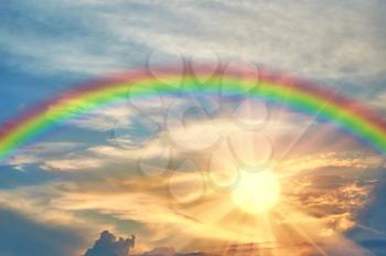 Rainbow in the beautiful sky at sunset and the radiant sun