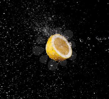 Water drops splashing onto a lemon