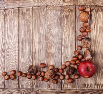 Autumn harvest. Apple and nuts on  on dark recycled wood background, with copy space.. Top veiw