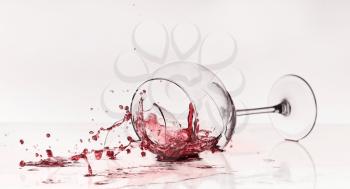 Broken wineglass on the table. Poured red wine, like blood.