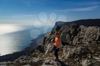 young fitness woman trail runner on sunrise seaside trail. Crimean mountains. Idea and concept of freedom and rest