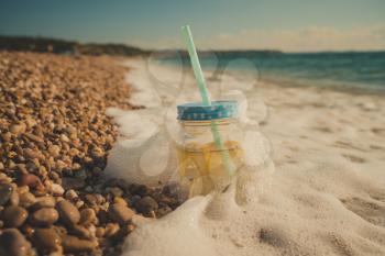 mojito on summer sandy beach. Mojito in glass jars on the sea coast. summer beach fun in the sea