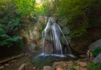 Mountain River with, forest landscape. Tranquil waterfall scenery in the middle of green forest. Beautiful Crimean waterfall Dzhur-dzhur