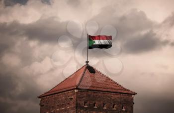 Flag with original proportions. Flag of the Sudan. beautiful flailing flag on the roof of the old fortress