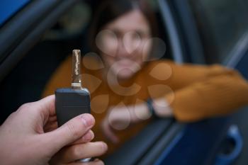 Auto Dealer Giving asian Woman Automobile Key For Test Drive. Selective Focus. The concept of buying or leasing auto