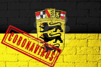 Flag of the regions of Germany Baden-Wurttemberg with original proportions. stamped of Coronavirus. brick wall texture. Corona virus concept. On the verge of a COVID-19 or 2019-nCoV Pandemic.