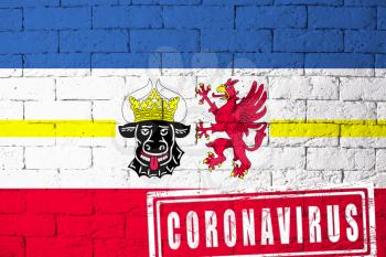 Flag of the regions of Germany Mecklenburg-Vorpommern with original proportions. stamped of Coronavirus. brick wall texture. Corona virus concept. On the verge of a COVID-19 or 2019-nCoV Pandemic.