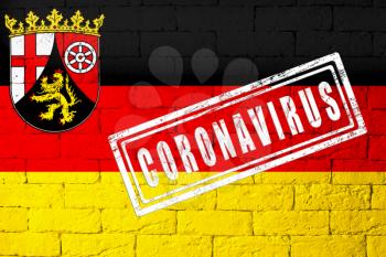 Flag of the regions of Germany Rhineland-Palatinate with original proportions. stamped of Coronavirus. brick wall texture. Corona virus concept. On the verge of a COVID-19 or 2019-nCoV Pandemic.