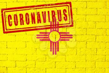 Flag of the State of New Mexico painted on grungy brick wall background. with stamp CORONAVIRUS, idea and concept of healthcare, epidemic and disease in USA