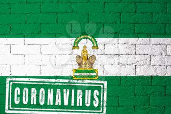 Flag of the regions or communities of Spain Andalucia with original proportions. stamped of Coronavirus. brick wall texture. Corona virus concept. On the verge of a COVID-19 or 2019-nCoV Pandemic.