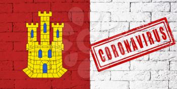 Flag of the regions or communities of Spain Castilla-La Mancha. stamped of Coronavirus. brick wall texture. Corona virus concept. On the verge of a COVID-19 or 2019-nCoV Pandemic.