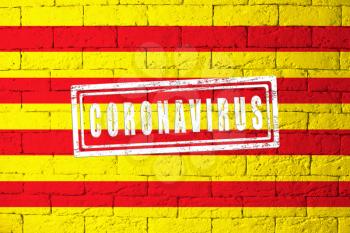 Flag of the regions or communities of Spain Catalonia with original proportions. stamped of Coronavirus. brick wall texture. Corona virus concept. On the verge of a COVID-19 or 2019-nCoV Pandemic.