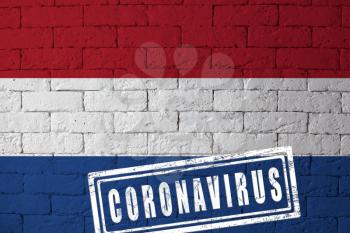 Flag of the Netherlands or Holland with original proportions. stamped of Coronavirus. brick wall texture. Corona virus concept. On the verge of a COVID-19 or 2019-nCoV Pandemic.