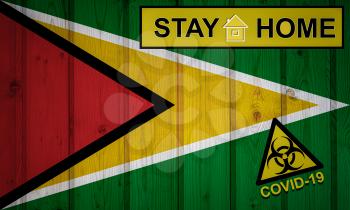 Flag of the Guyana in original proportions. Quarantine and isolation - Stay at home. flag with biohazard symbol and inscription COVID-19.