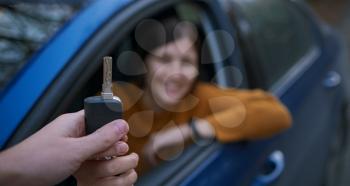 Auto Dealer Giving asian Woman Automobile Key For Test Drive. Selective Focus. The concept of buying or leasing auto