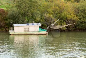 Small houseboat on side of River Danube used for fishing near Vienna, Austria