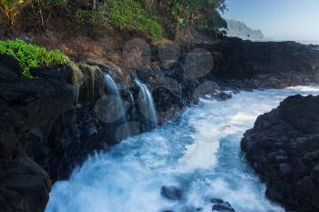 Waves crash into narrow gully by Queens Bath Princeville, Kauai, Hawaii