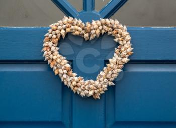 Heart shaped front door wreath made out of cone shapes of sea shells