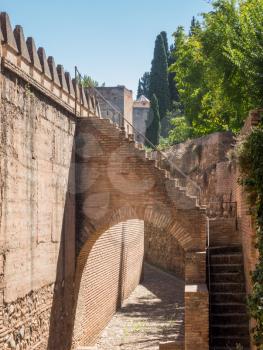 Strong castle walls surround gardens and Palacios Nazaries in Alhambra palace in ancient city of Granada in Andalucia, Spain, Europe