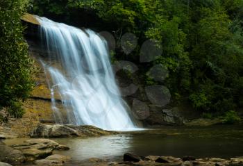 Blurred motion water of Silver Run falls cascade into shaded pool near Cashiers North Carolina
