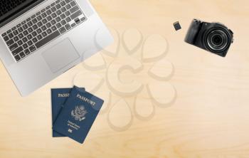Photographers organized desk with laptop camera, memory cards and USA passports