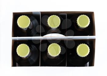 Pattern of six beer bottles in cardboard container with gold caps facing upwards