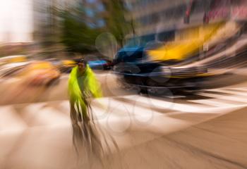 Abstract treatment of cyclist in busy traffic on bike on his daily commute to work in Washington DC as he cross a pedestrian crossing