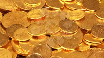 Gold Eagle one ounce coins lying on top of other golden money suggesting immense wealth