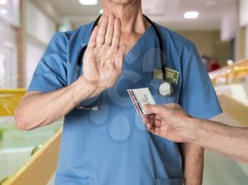 Senior caucasian doctor in scrubs in hospital refusing to treat a patient with a Medicare card