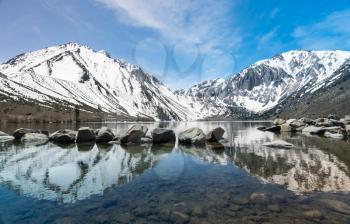 Reflection of snow covered mountains in picturesque Convict Lake in Sierra Nevada California