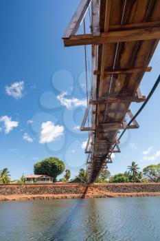 View from underneath the famous wooden suspension swinging bridge to cross the river in Hanapepe Kauai