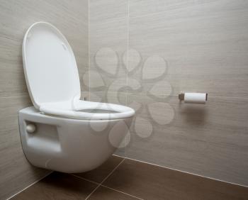 Modern flush toilet or WC in small bathroom with push button flush