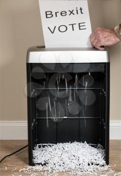 Brexit paper vote being shredded as a wasted vote in an office shredder