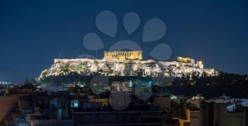 Acropolis hill at night with the city of Athens surrounding it