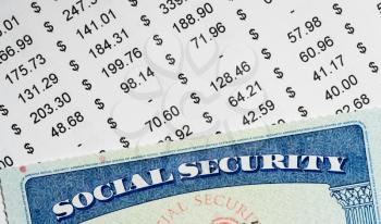 Social Security card in the USA laid on top of figures and calculation of budget in retirement