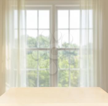 Background image of wooden desk or table in front of bright summery window with room for products or composited objects
