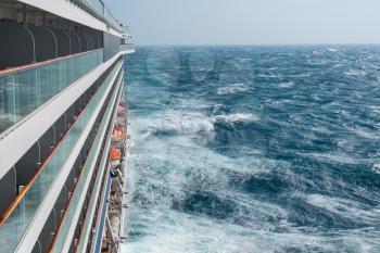 View from cabin balconies at the rough seas and waves off the side of cruise ship
