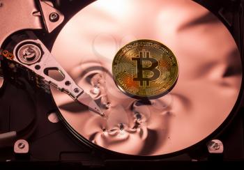 Bitcoin superimposed on the damaged discs of a hard drive storage to illustrate bitcoin market crash