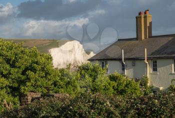 Old Coastguard cottage on the cliffs at Cuckmere Haven in East Sussex with Seven Sisters in the background