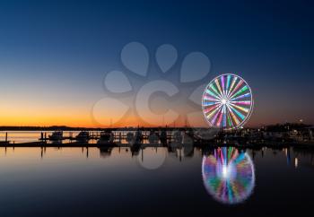 Illuminated ferris wheel at National Harbor near the nation capital of Washington DC at sunset