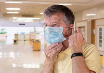Senior caucasian man adjusting his face mask and looking concerned about coronavirus epidemic. Composite inside shopping mall