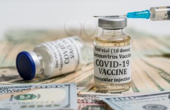 Covid-19 coronavirus vaccine with hypodermic syringe needle sitting on pile of cash to suggest payment to get the vaccination
