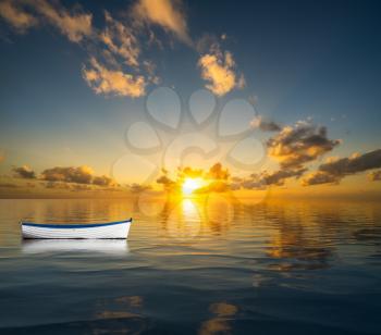 White rowing boat without people drifting on the open sea towards a sunset to illustrate leadership crisis