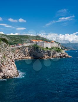 Vertical format of the city walls of the old town in Dubrovnik and coastline