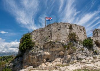 Croatian flag flies above ruins of old Venetian fort above the coastal town of Novigrad in Croatia