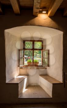 Simple window and window seat in solid stone wall in old castle