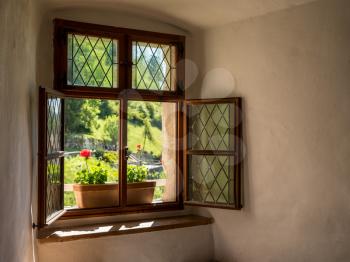 Simple window wiht flower box in solid stone wall in old castle