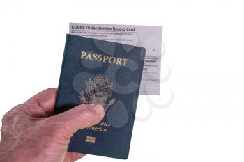 Senior man hand holding USA passport and vaccination certificate or record card for coronavirus