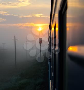 Passenger train rides against the sunset, Railway at sunset